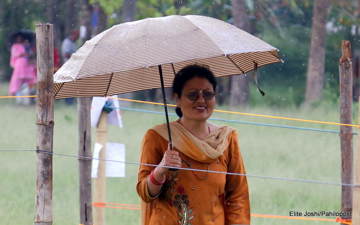 फोटोमा हेर्नुस्, वर्षाले रोकेन मतदाताको उत्साह, छाताको साहारामा भक्तपुरमा मतदान